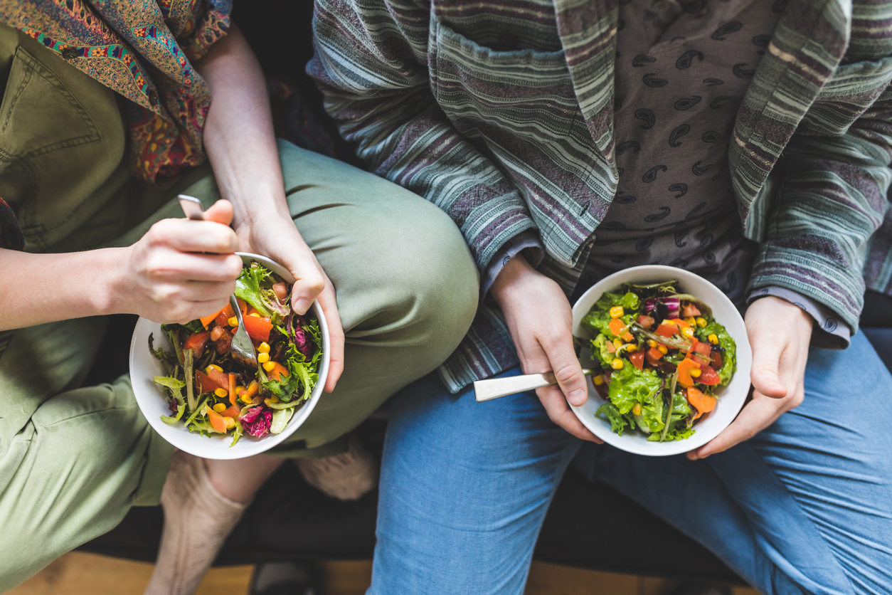 Two people eating fresh salad bowls together